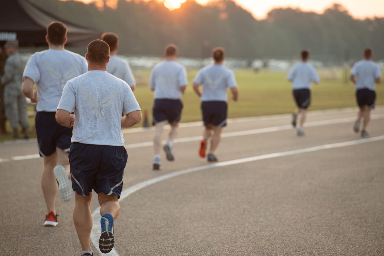 Airmen running at sunrise during Air Force PT in official PT uniforms