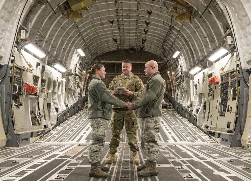 An Air Force couple holds a wedding ceremony inside a C-17 cargo compartment at Dover Air Force Base
