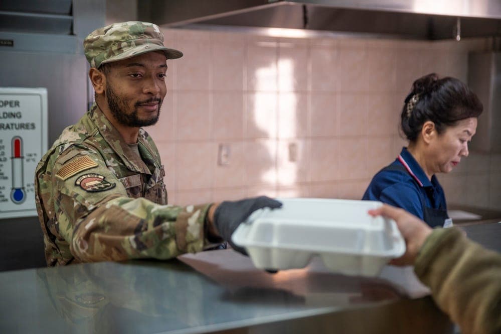 Airmen selecting food at a dining facility serving line