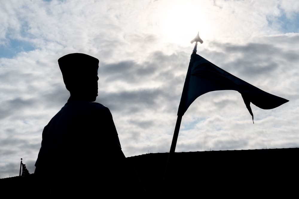 Airmen silhouetted during Airman's Week ceremony with guidon