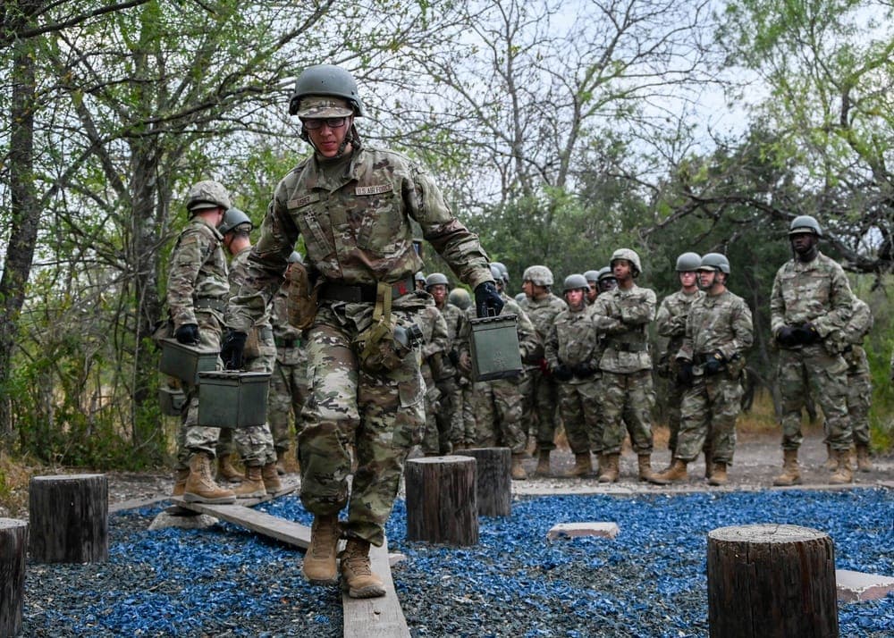 Airmen working together on confidence course obstacle during training