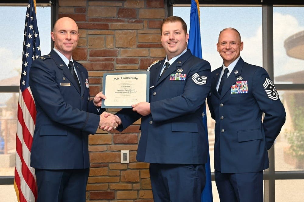 Air Force members receiving Community College of the Air Force degrees during a graduation ceremony