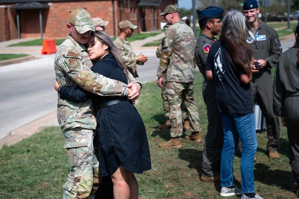 Air Force Airman embracing family members during a deployment homecoming ceremony
