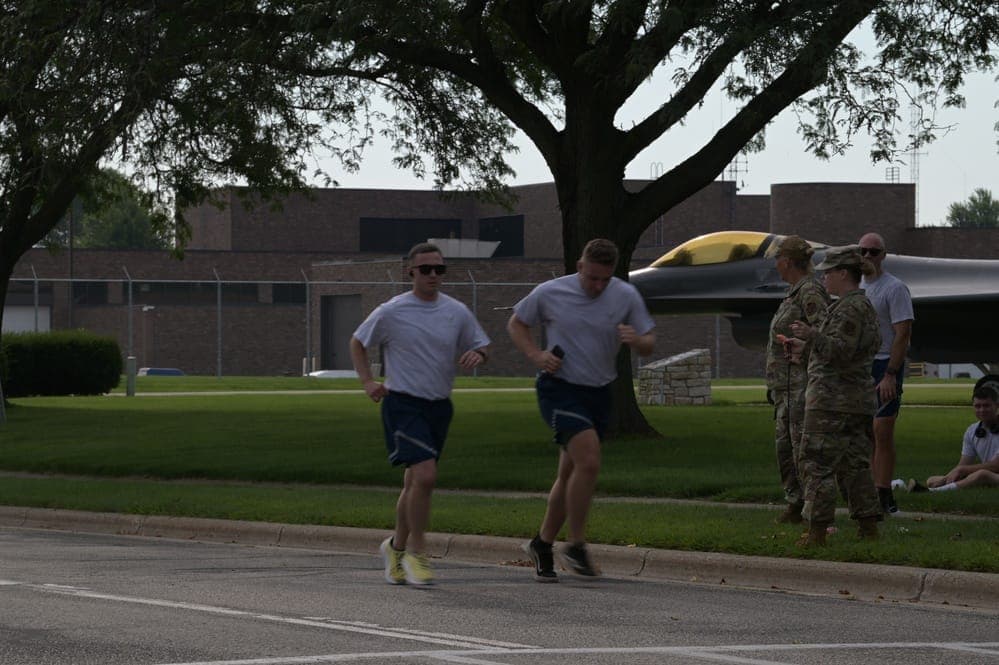 Airmen running during a Physical Fitness Assessment on an outdoor track
