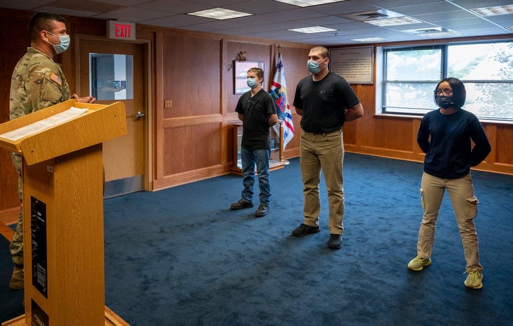 Military applicants attending an evening briefing at a MEPS hotel before processing day