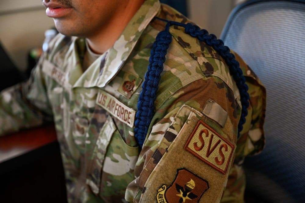 An MTL wearing the distinctive dark blue aiguillette speaking with Airmen at a technical training location