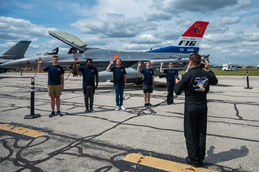 Air Force recruits taking the oath of enlistment in front of an F-16 at Thunder Over Michigan airshow