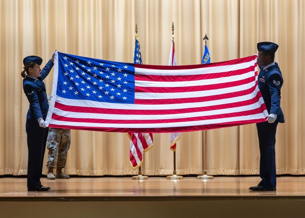 Air Force honor guard members folding the American flag during a military retirement ceremony