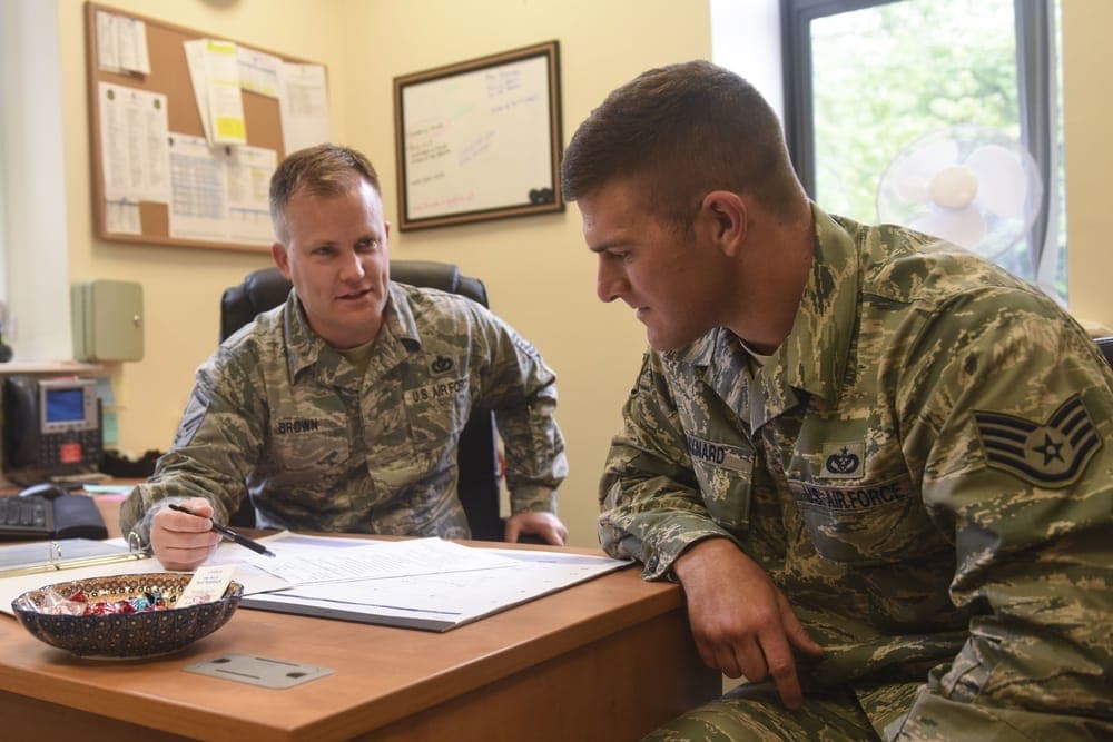 Air Force Development Advisor counseling an Airman on career options at a desk