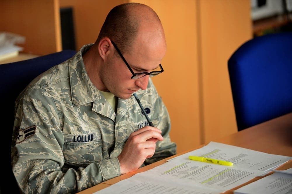 Airman studying Career Development Course materials at desk